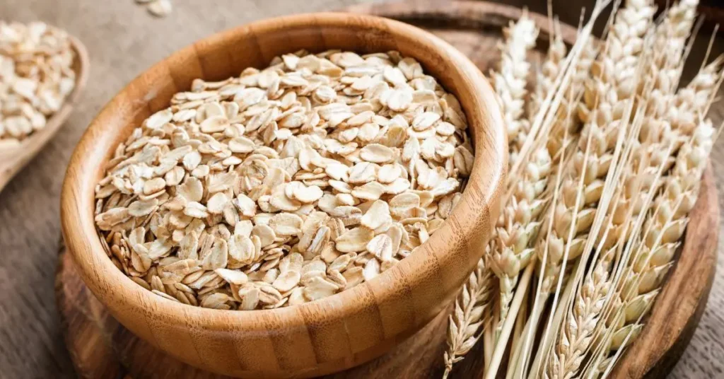 लकड़ी के बाउल में रखे हुए ताजे oats और गेहूं की बालियाँ