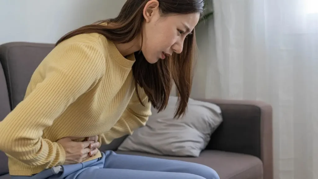 Loose Motion में पेट दर्द से पीड़ित महिला