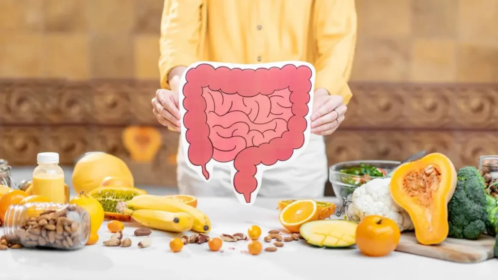 Gut health गट हेल्थ के लिए आंतों का चित्र और आसपास रखे फल, सब्ज़ियां और हेल्दी फूड